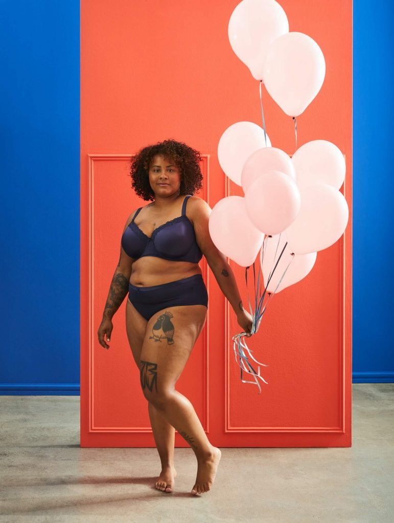 Body positive woman hlding balloons in her underwear